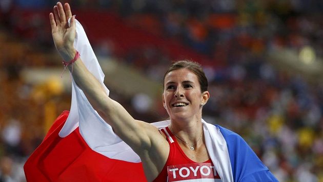 Zuzana Hejnová s českou vlajkou zdraví fanoušky po triumfu ve finále na 400 m překážek na MS v Moskvě. Zuzana Hejnová s českou vlajkou zdraví fanoušky po triumfu ve finále na 400 m překážek na MS v Moskvě.