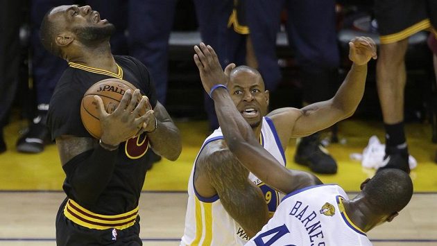 Hvězda Clevelandu LeBron James (vlevo) se snaží prosadit přes dvojici bránících hráčů Golden State Harrisona Barnese a Andrého Iguodalu. Hvězda Clevelandu LeBron James (vlevo) se snaží prosadit přes dvojici bránících hráčů Golden State Harrisona Barnese a Andrého Iguodalu.