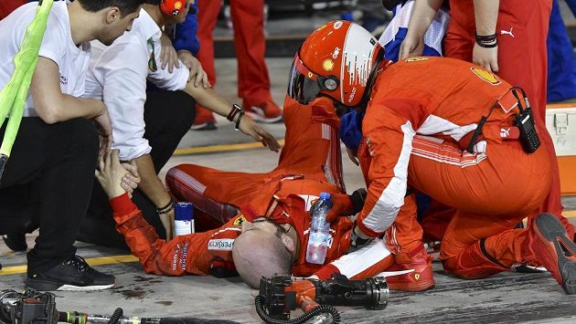 Zraněný mechanik Ferrari leží na zemi poté, co mu Kimi Räikkönen přejel nohu. Zraněný mechanik Ferrari leží na zemi poté, co mu Kimi Räikkönen přejel nohu.