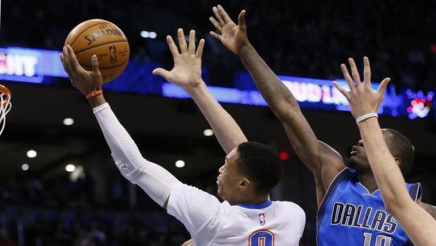 Russell Westbrook (0) z Oklahomy se prosadil přes obranu Dallasu a dává koš. Russell Westbrook (0) z Oklahomy se prosadil přes obranu Dallasu a dává koš.