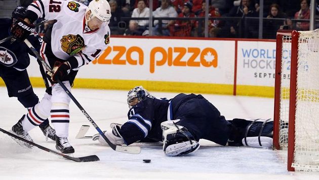 Český forvard Tomáš Fleischmann (12) z Chicaga překonává svého krajana v bráně Winnipegu Ondřeje Pavelce (30) v zápase NHL. Český forvard Tomáš Fleischmann (12) z Chicaga překonává svého krajana v bráně Winnipegu Ondřeje Pavelce (30) v zápase NHL.