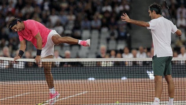 Rafael Nadal (vlevo) přeskakuje síť a Nadal na něj pobaveně zírá. Rafael Nadal (vlevo) přeskakuje síť a Nadal na něj pobaveně zírá.