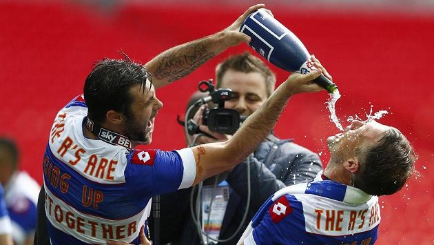 Charlie Austin (vlevo) a Clint Hill z Queens Park Rangers slaví návrat do Premier League. Charlie Austin (vlevo) a Clint Hill z Queens Park Rangers slaví návrat do Premier League.