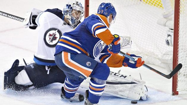 Ondřej Pavelec čelí nájezdu Matta Hendrickse. Ondřej Pavelec čelí nájezdu Matta Hendrickse.