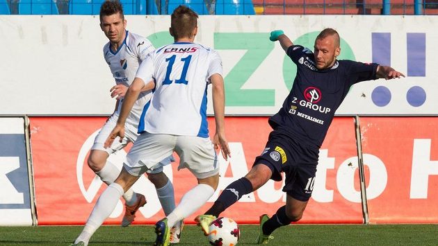 Jakub Petr ze Slovácka se snaží přejít přes záložníka Baníku Ostrava Jána Greguše. Vlevo přihlíží ostravský Davor Kukec. Jakub Petr ze Slovácka se snaží přejít přes záložníka Baníku Ostrava Jána Greguše. Vlevo přihlíží ostravský Davor Kukec.