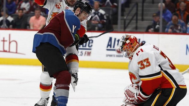 Hokejista Colorada Avalanche Matt Calvert před brankářem Calgary Davidem Rittichem. Hokejista Colorada Avalanche Matt Calvert před brankářem Calgary Davidem Rittichem.