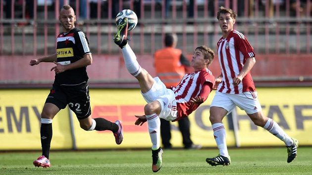 Ondřej Karafiát z Žižkova (uprostřed) odkopává míč před slávistickým záložníkem Jakubem Petrem. Ondřej Karafiát z Žižkova (uprostřed) odkopává míč před slávistickým záložníkem Jakubem Petrem.