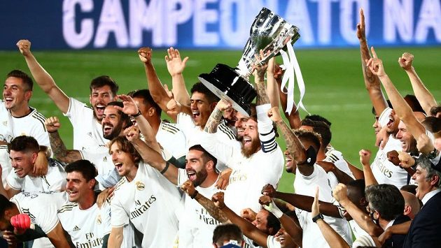 Hráči Realu Madrid slaví, Sergio Ramos drží pohár, jeho tým získal 34. titul. Hráči Realu Madrid slaví, Sergio Ramos drží pohár, jeho tým získal 34. titul.
