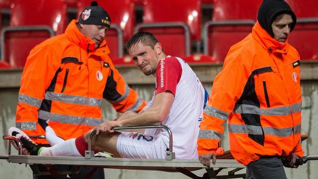 Zraněný útočník Slavie Praha Lukáš Železník opouští hrací plochu v Edenu na nosítkách. Zraněný útočník Slavie Praha Lukáš Železník opouští hrací plochu v Edenu na nosítkách.