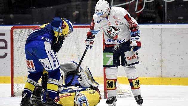 Brankář Zlína Libor Kašík je na lopatkách, pardubický Tomáš Rolinek do něj lehce šťouchá hokejkou. Vše sleduje jeden ze zlínských obránců. Brankář Zlína Libor Kašík je na lopatkách, pardubický Tomáš Rolinek do něj lehce šťouchá hokejkou. Vše sleduje jeden ze zlínských obránců.