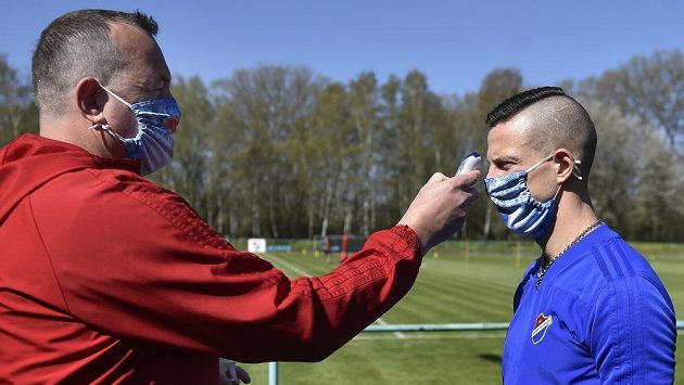 Fotbalisté Baníku Ostrava na tréninku. Masér Michal Čaja (vlevo) měřil každému z příchozích teplotu a dezinfikoval ruce. Vpravo je Jiří Fleišman. Fotbalisté Baníku Ostrava na tréninku. Masér Michal Čaja (vlevo) měřil každému z příchozích teplotu a dezinfikoval ruce. Vpravo je Jiří Fleišman.