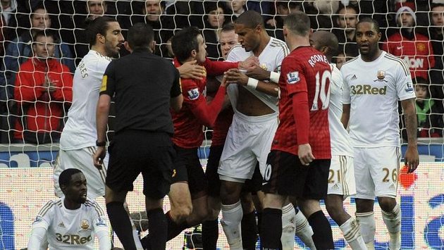 Útočník Manchesteru United se sápe na Ashleyho Williamse ze Swansea, který jej chvíli předtím trefil v přerušené hře míčem do hlavy. Útočník Manchesteru United se sápe na Ashleyho Williamse ze Swansea, který jej chvíli předtím trefil v přerušené hře míčem do hlavy.