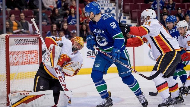 Brankář David Rittich (33) při zákroku proti Vancouveru před Brendanem Gauncem (50) z Vancouveru a Mikaelem Backlundem (11) z Calgary. Brankář David Rittich (33) při zákroku proti Vancouveru před Brendanem Gauncem (50) z Vancouveru a Mikaelem Backlundem (11) z Calgary.