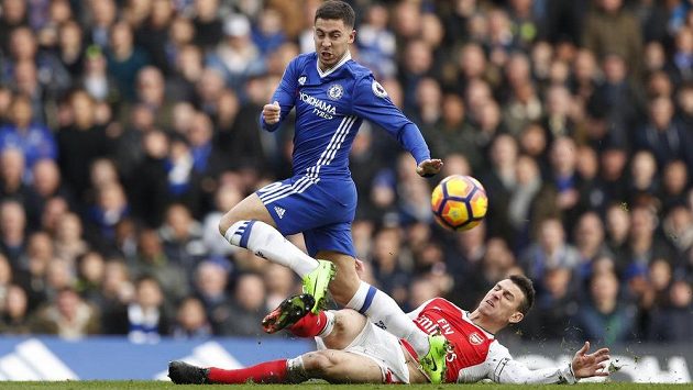 Belgickou hvězdu Chelsea Edena Hazarda se skluzem snaží zastavit Laurent Koscielny z Arsenalu. Belgickou hvězdu Chelsea Edena Hazarda se skluzem snaží zastavit Laurent Koscielny z Arsenalu.