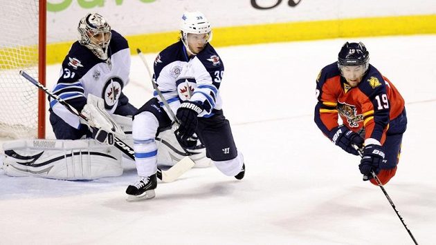 Brankář Winnipegu Ondřej Pavelec (vlevo) a obránce Tobias Enstrom (uprostřed) sledují střílejícího Scottieho Upshalla z Floridy. Brankář Winnipegu Ondřej Pavelec (vlevo) a obránce Tobias Enstrom (uprostřed) sledují střílejícího Scottieho Upshalla z Floridy.
