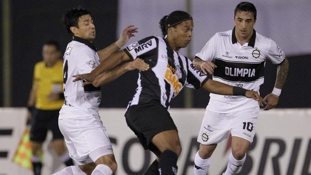 Největší hvězda Atlétika Mineiro Ronaldinho (uprostřed) bojuje o míč s Lorenzem Arandou (vlevo) a Juanem Salgueirem z paraguayské Olimpie. Největší hvězda Atlétika Mineiro Ronaldinho (uprostřed) bojuje o míč s Lorenzem Arandou (vlevo) a Juanem Salgueirem z paraguayské Olimpie.