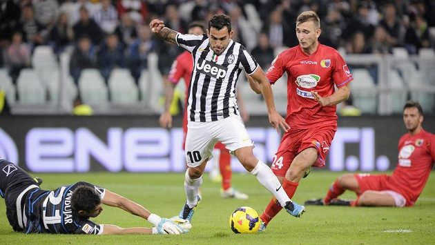 Carlos Tévez, útočník Juventusu, po driblinku obranou Catanie překonává brankáře Mariana Andujara. Carlos Tévez, útočník Juventusu, po driblinku obranou Catanie překonává brankáře Mariana Andujara.