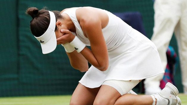Hotovo. Garbiňe Muguruzaová na kolenou v nevěřícném gestu po triumfu ve Wimbledonu. Hotovo. Garbiňe Muguruzaová na kolenou v nevěřícném gestu po triumfu ve Wimbledonu.