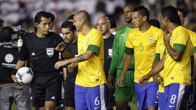 Brazilec Fabio Santos (druhý zleva) promlouvá k chilskému rozhodčímu Enrique Ossesovi během výpadku osvětlení na stadiónu v Resistencii. Brazilec Fabio Santos (druhý zleva) promlouvá k chilskému rozhodčímu Enrique Ossesovi během výpadku osvětlení na stadiónu v Resistencii.