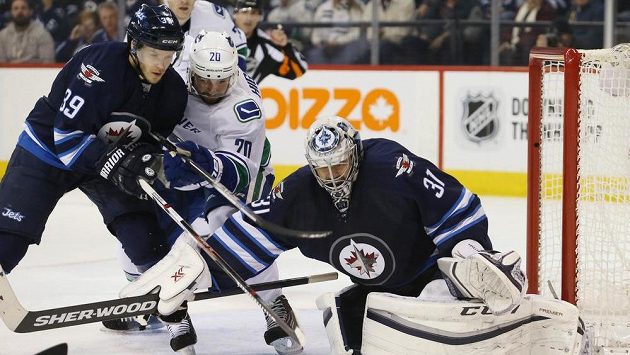 Český brankář Winnipegu Ondřej Pavelec (vpravo) před dotírajícím Chrisem Wigginsem (20), jehož atakuje obránce Jets Tobias Enström (39). Český brankář Winnipegu Ondřej Pavelec (vpravo) před dotírajícím Chrisem Wigginsem (20), jehož atakuje obránce Jets Tobias Enström (39).