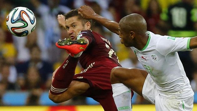 Rus Alexej Kozlov (vlevo) odkopává míč před Jasínem Brahímím z Alžírska. Rus Alexej Kozlov (vlevo) odkopává míč před Jasínem Brahímím z Alžírska.