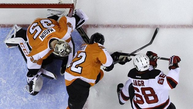 Útočník New Jersey Devils Jaromír Jágr (68) střílí gól brankáři Flyers Stevemu Masonovi (35). Útočník New Jersey Devils Jaromír Jágr (68) střílí gól brankáři Flyers Stevemu Masonovi (35).