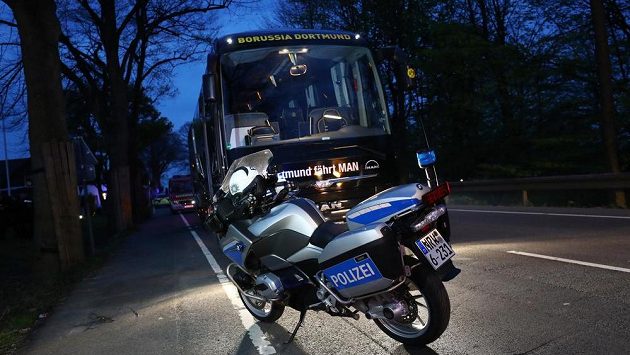 Policejní motocykl před autobusem fotbalistů Dortmundu, který poničila exploze. Policejní motocykl před autobusem fotbalistů Dortmundu, který poničila exploze.