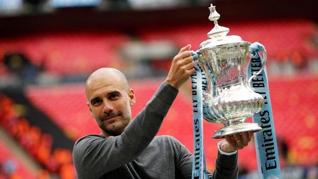 Španělský kouč Josep Guardiola pózuje s trofejí pro vítěze FA Cupu. Španělský kouč Josep Guardiola pózuje s trofejí pro vítěze FA Cupu.