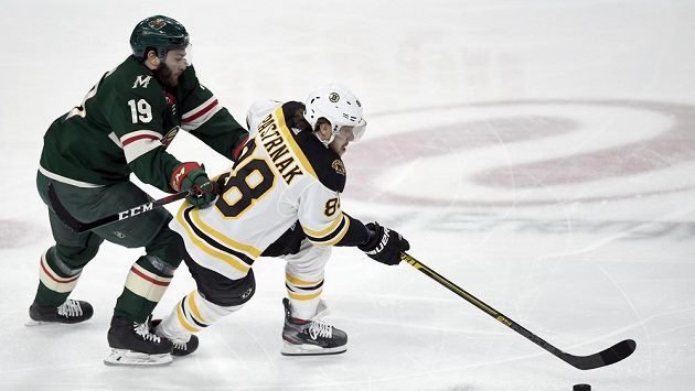 Český hokejista Bostonu David Pastrňák (v bílém) ujíždí Lukeovi Kuninovi z Minnesoty v zápase NHL. Český hokejista Bostonu David Pastrňák (v bílém) ujíždí Lukeovi Kuninovi z Minnesoty v zápase NHL.