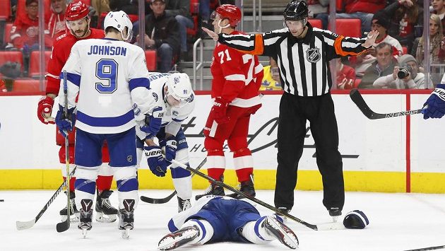 Obránce Tampy Bay Dan Girardi leží na ledě poté, co ho zasáhl projektil z hokejky českého útočníka Detroitu Martina Frka (zcela vlevo). Obránce Tampy Bay Dan Girardi leží na ledě poté, co ho zasáhl projektil z hokejky českého útočníka Detroitu Martina Frka (zcela vlevo).
