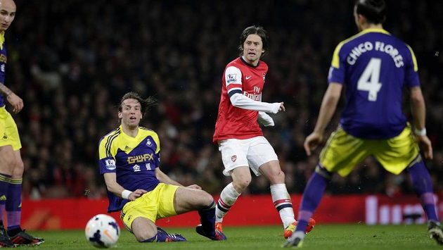 Záložník Arsenalu Tomáš Rosický (uprostřed) přihrává míč mezi hráči Swansea City Michuem (na zemi) a Chico Floresem. Záložník Arsenalu Tomáš Rosický (uprostřed) přihrává míč mezi hráči Swansea City Michuem (na zemi) a Chico Floresem.