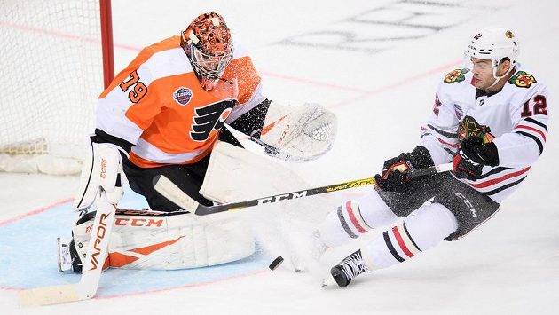 Brankář Philadelphie Carter Hart a Alex DeBrincat z Chicaga. Brankář Philadelphie Carter Hart a Alex DeBrincat z Chicaga.