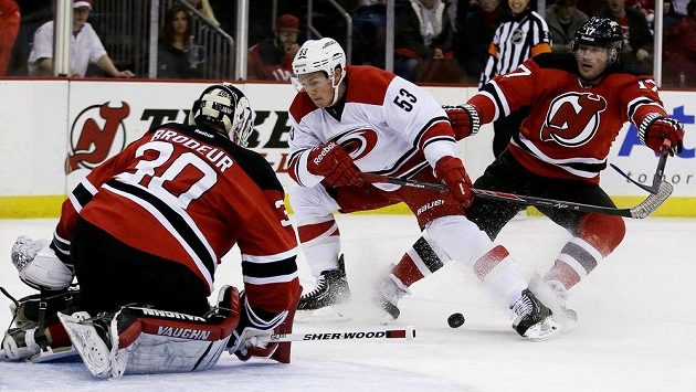 Útočník Jeff Skinner (uprostřed) z Caroliny se snaží vyzrát na Martina Brodeura v brance New Jersey, situaci sleduje Michael Ryder. Útočník Jeff Skinner (uprostřed) z Caroliny se snaží vyzrát na Martina Brodeura v brance New Jersey, situaci sleduje Michael Ryder.
