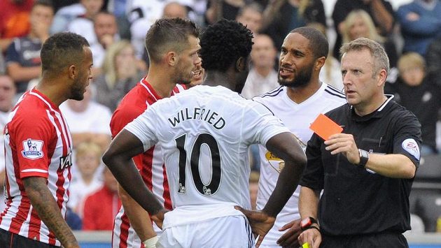 Útočník Swansea Bony Wilfried přihlíží, jak sudí Jonathan Moss vytahuje červenou kartu. Útočník Swansea Bony Wilfried přihlíží, jak sudí Jonathan Moss vytahuje červenou kartu.