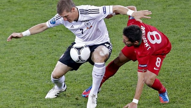 Bastian Schweinsteiger (vlevo) si kryje míč před dotírajícím Portugalcem Joaem Moutinhem Bastian Schweinsteiger (vlevo) si kryje míč před dotírajícím Portugalcem Joaem Moutinhem