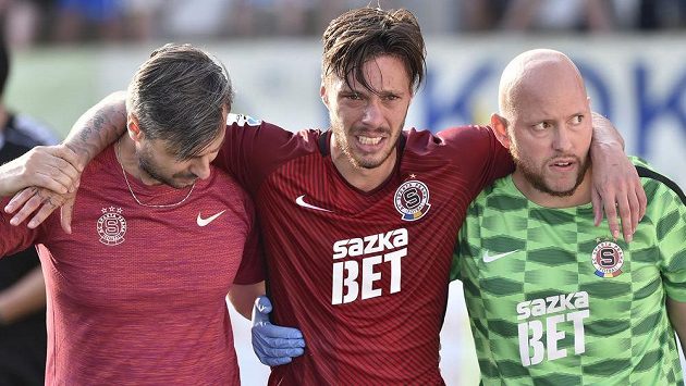 Lékař Sparty Miroslav Sinkule (vlevo) a masér Kamil Maixner (vpravo) pomáhají zraněnému útočníkovi Sparty Václavu Kadlecovi. Lékař Sparty Miroslav Sinkule (vlevo) a masér Kamil Maixner (vpravo) pomáhají zraněnému útočníkovi Sparty Václavu Kadlecovi.