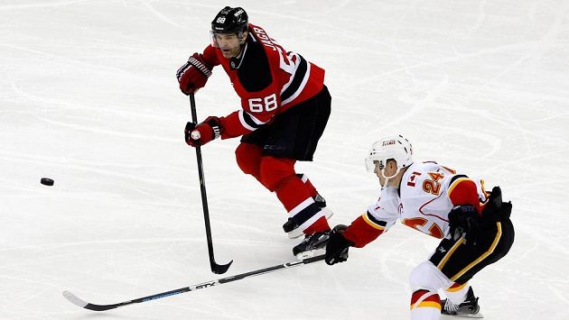 Jiří Hudler z Calgary (vpravo) se snaží zastavit puk mířící na Jaromíra Jágra z New Jersey. Jiří Hudler z Calgary (vpravo) se snaží zastavit puk mířící na Jaromíra Jágra z New Jersey.