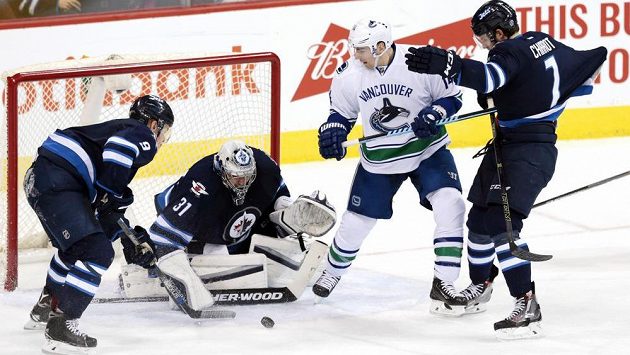 Ondřej Pavelec v brance Winnipegu řeší za asistence spoluhráčů šanci křídelníka Vancouveru Alexe Burrowse. Ondřej Pavelec v brance Winnipegu řeší za asistence spoluhráčů šanci křídelníka Vancouveru Alexe Burrowse.