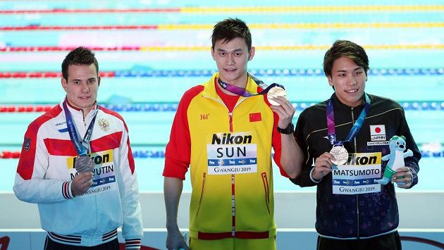 Čínský plavec Sun Jang (uprostřed) se zlatou medialí při ceremoniálu na MS po závodu na 200m volný způsob. Čínský plavec Sun Jang (uprostřed) se zlatou medialí při ceremoniálu na MS po závodu na 200m volný způsob.