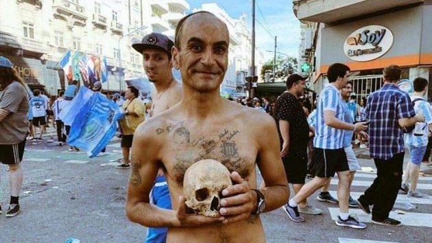 Fanoušek argentinského Racing Club pózuje s lebkou svého dědy během oslav mistrovského titulu. Fanoušek argentinského Racing Club pózuje s lebkou svého dědy během oslav mistrovského titulu.