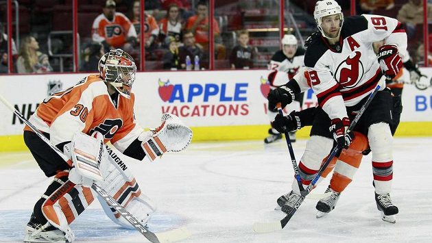 Brankář Philadelphie Michal Neuvirth zasahuje v utkání proti New Jersey. Vpravo je útočník Devils Travis Zajac. Brankář Philadelphie Michal Neuvirth zasahuje v utkání proti New Jersey. Vpravo je útočník Devils Travis Zajac.