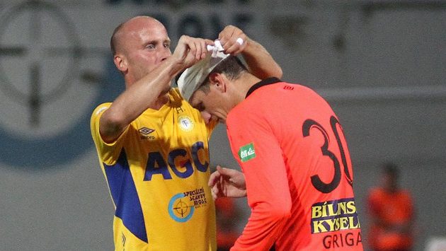Teplický hráč Ivo Táborský upravuje obvaz brankáři Tomáši Grigarovi v utkání s Plzní. Teplický hráč Ivo Táborský upravuje obvaz brankáři Tomáši Grigarovi v utkání s Plzní.