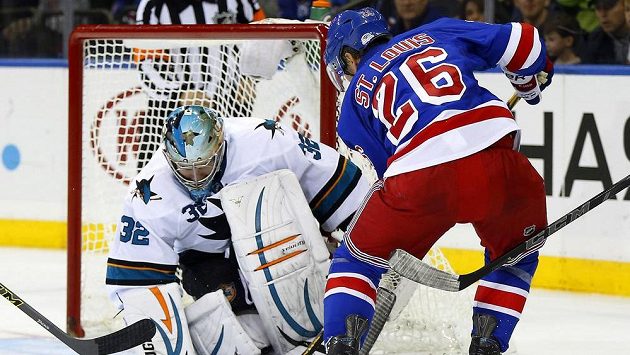Útočník Rangers Martin St. Louis překonává gólmana San Jose Alexe Stalocka. Útočník Rangers Martin St. Louis překonává gólmana San Jose Alexe Stalocka.