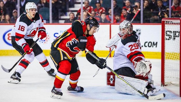 Gólman New Jersey Devils zasahuje proti útočícímu hráči Flames Johnnymu Gaudreauovi. Utkání vyhráli Flames poměrem 9:4. Gólman New Jersey Devils zasahuje proti útočícímu hráči Flames Johnnymu Gaudreauovi. Utkání vyhráli Flames poměrem 9:4.