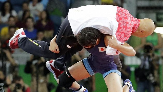 Japonská zápasnice Risako Kawaiová na oslavu svého vítězství přehazuje svého trenéra na žíněnku. Japonská zápasnice Risako Kawaiová na oslavu svého vítězství přehazuje svého trenéra na žíněnku.