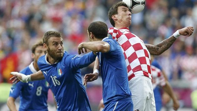 Chorvat Mario Mandžukič (vpravo) v obležení Italů De Rossiho (vlevo) a Chielliniho Chorvat Mario Mandžukič (vpravo) v obležení Italů De Rossiho (vlevo) a Chielliniho