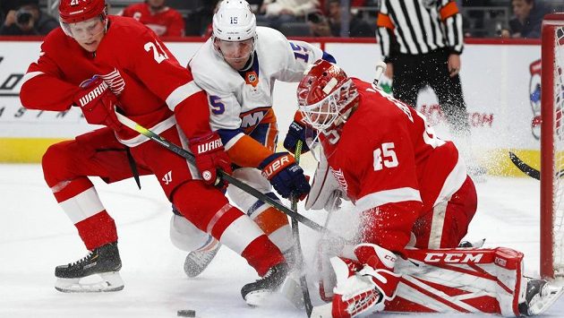 Brankář Detroitu Jonathan Bernier zastavuje za pomoci Dennise Cholowského akci Cala Clutterbucka z New York Islanders. Brankář Detroitu Jonathan Bernier zastavuje za pomoci Dennise Cholowského akci Cala Clutterbucka z New York Islanders.