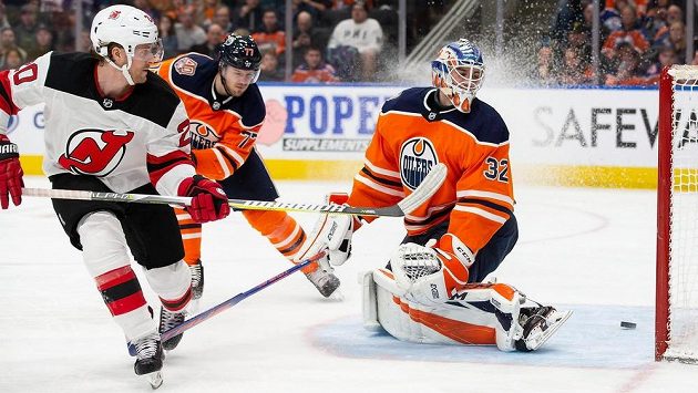 Blake Coleman (vlevo) z New Jersey Devils překonává brankáře Edmontonu Oilers Anthonyho Stolarze v utkání NHL. Blake Coleman (vlevo) z New Jersey Devils překonává brankáře Edmontonu Oilers Anthonyho Stolarze v utkání NHL.