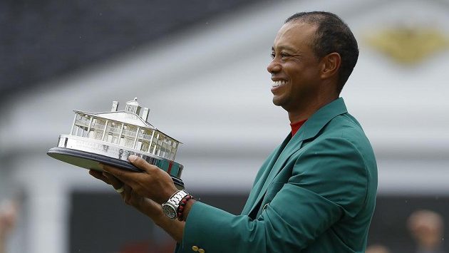 Tiger Woods s tradičním zeleným sakem pro vítěze a trofejí. Tiger Woods s tradičním zeleným sakem pro vítěze a trofejí.