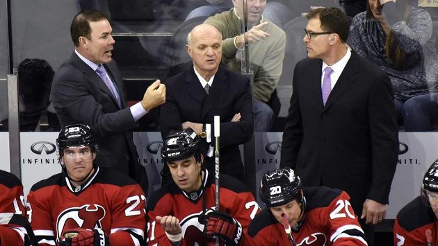 Generální manažer New Jersey Lou Lamoriello (uprostřed vzadu) s koučem pro ofenzivu Adamem Oatesem (vlevo) a defenzivu Scottem Stevensem. Generální manažer New Jersey Lou Lamoriello (uprostřed vzadu) s koučem pro ofenzivu Adamem Oatesem (vlevo) a defenzivu Scottem Stevensem.